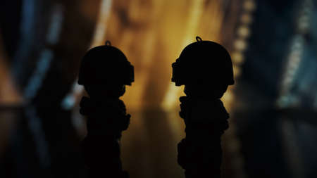 TOMSK, RUSSIA - May 21, 2020: Two little toy man from the PUBG game with a rifle stands on a table against the color background. Silhouetteのeditorial素材