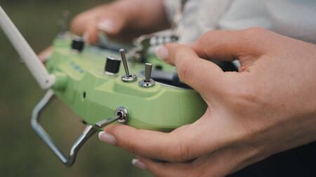 Closeup female hands remote control sticks of control of FPV racing droneの写真素材