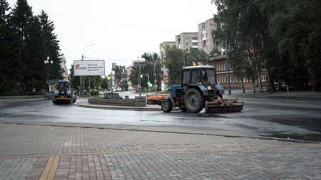 TOMSK, RUSSIA - June 2, 2020: tractors drive down the street and clean the asphaltのeditorial素材