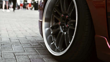 Side view of a red sports car and a stylish wheel