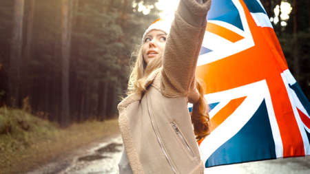 The girl holds the flag of United Kingdom in hands. Portrait shootの写真素材