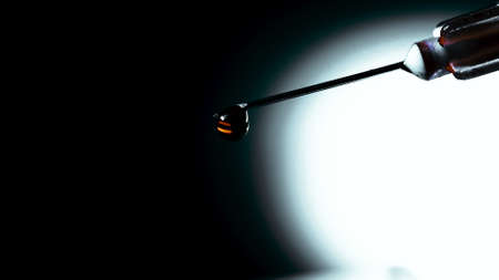 Blood drips from the tip of the needle. Close up
