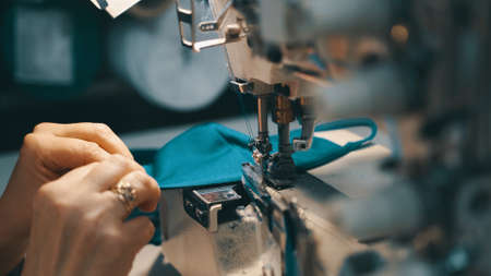 Woman seamstress works at a sewing machine
