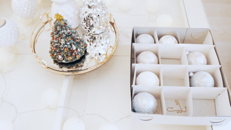 The girl takes beautiful shiny Christmas toys from the box