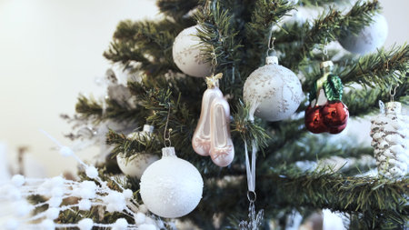 Beautiful light-colored toys hang on the Christmas tree at home. Palettes
