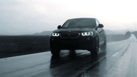 ALTAI, RUSSIA - 29 JUNE 2021: Black BMW X4 drives down the highway. FRONT view Close up