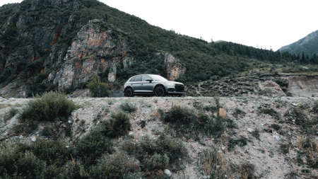 ALTAI, RUSSIA - 29 JUNE 2021: Audi Q5 drone flying back off a cliff footage against the backdrop of...