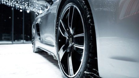 ST. PETERSBURG, RUSSIA - 12 DECEMBER 2020: Silver Porsche 718 Boxter stands in the open air at night, it is snowing. wheels close-upのeditorial素材