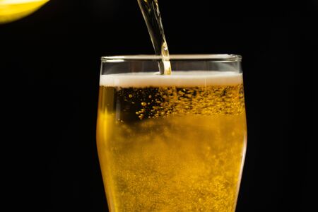 Close-up of goblets with pouring beerの写真素材