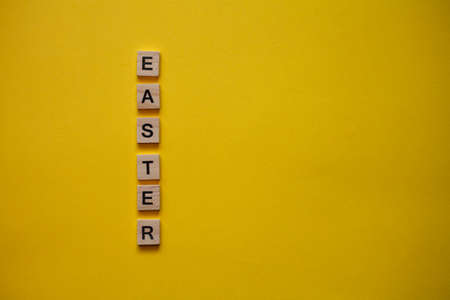 light wooden letters on a yellow background. Flat layの写真素材