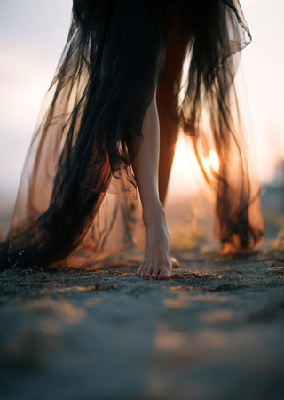 Beautiful girl with long black hair walking on the beach at sunsetの素材