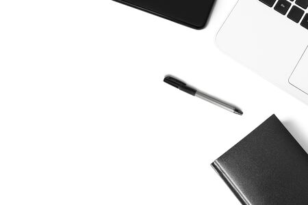 Black pen, smartphone, white laptop on a white background. The concept of business, training, workplace. Minimalistic monochrome flat lay.の写真素材