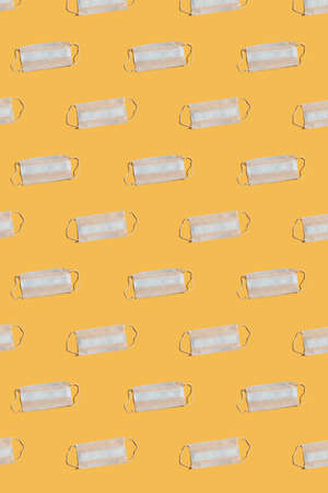 Pattern and medical masks on a yellow background. Concept of pandemic, epidemic, virus, quarantine.の写真素材