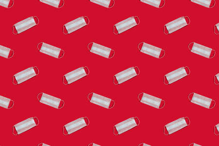 Pattern and medical reusable masks on a red background. Concept of pandemic, epidemic, virus,...