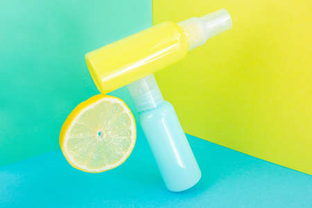 Yellow and blue cosmetic bottles on the same colored background. Stylish concept of organic...