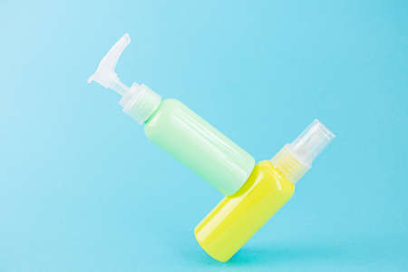 Yellow and blue cosmetic bottles on the same colored background. Stylish concept of organic...