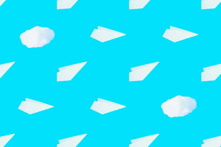 Pattern from white paper airplanes and cotton clouds on a blue background. Creative concept of...