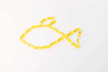 Vitamin omega3 concept, fish oil. The capsules are laid out in the shape of a fish. Copy space, minimalism, top view.