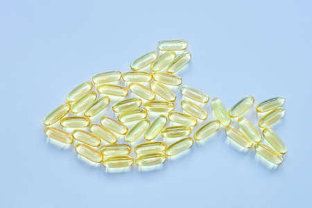 Vitamin omega3 concept, fish oil. The capsules are laid out in the shape of a fish. Copy space,...