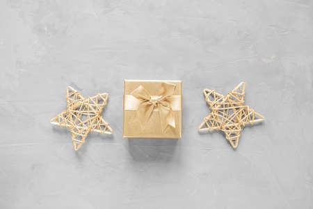 New Year's flat lay in golden and gray shades. Gift box and stars are painted with golden paint....