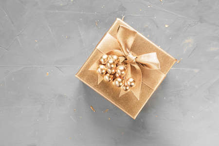 New Year's flat lay in golden and gray shades. Gift box and berries are painted with golden paint....