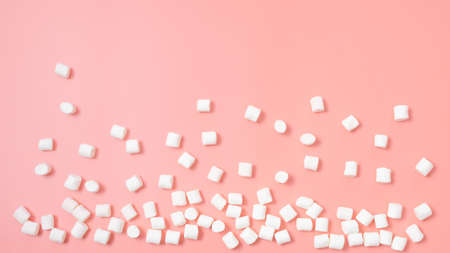 Marshmallows scattered on a pink background. Sweets concept. Top view, minimalism.の写真素材