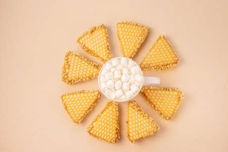 Cozy home still life: white cup with cocoa with marshmallows and cookie on pastel background. The...