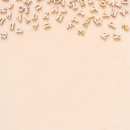 Wooden English letters are scattered over the light surface. Concept for alphabet, writing and...