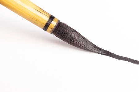 Chinese art brush ink on white paper. The concept of tools for painting, teaching drawing. Macro...