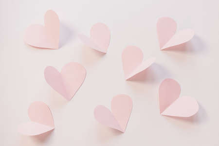 Pink paper hearts on a light pastel background. Concept of romance, love, valentine's day....