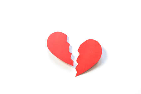 Red paper heart cut in two. The concept of unrequited love, parting, divorce, broken heart. Minimalism, paper art.の写真素材
