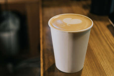 A paper coffee cup is on the counter in a coffee shop. Morning concept, coffee to go.の写真素材