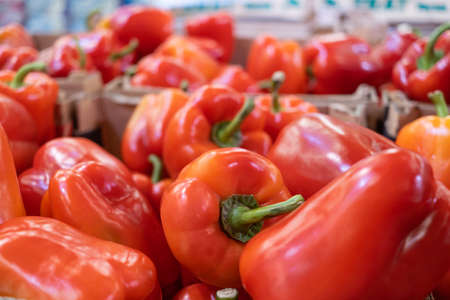 Ripe red peppers lie in a box in a supermarket. The concept of buying vegetables, sales.の写真素材