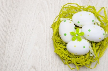painted easter eggs in a nest made of strawの写真素材