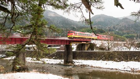 TSUWANO,JAPAN - NOVEMBER 28,2018:  Visitors waiting to take a picture of a red train running through...
