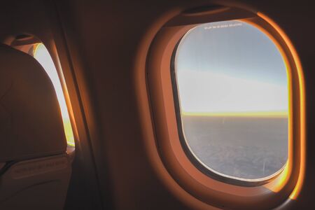 The morning sun shone through the glass on the plane to welcome tourists before arriving at the airport.の写真素材