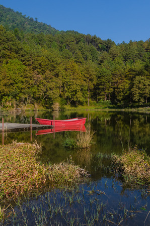 Red boat and reflection in lakeの写真素材