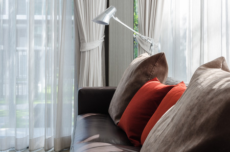 brown and red pillow on sofa with lamp in living room at homeの写真素材