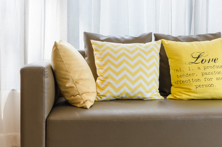 brown modern sofa with yellow pillowsの写真素材