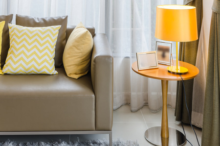 brown sofa with yellow pillows and lamp in living roomの写真素材
