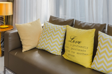 brown sofa with yellow pillows living roomの写真素材