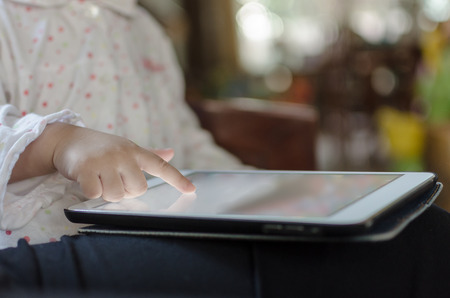 Children playing on digital tablet at homeの写真素材