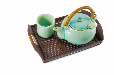 Chinese green teapot and teacups on the wooden trivet isolated on whiteの写真素材