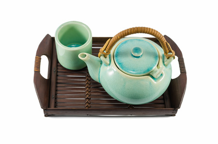 Chinese green teapot and teacups on the wooden trivet isolated on whiteの写真素材