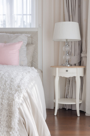 classic white lamp on wooden white table in bedroomの写真素材