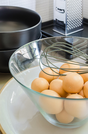 eggs in a glass bowl and egg shells in kitchenの写真素材