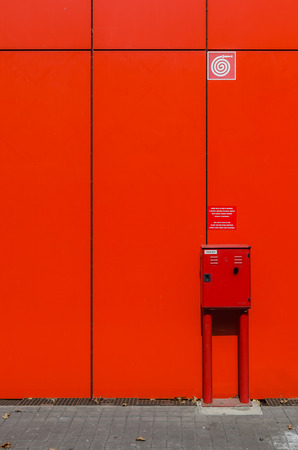 Fire hose cabinet on red wall at outdoorの写真素材
