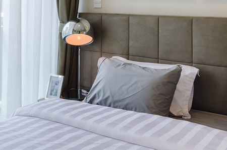 grey pillow on bed in bedroom at homeの写真素材