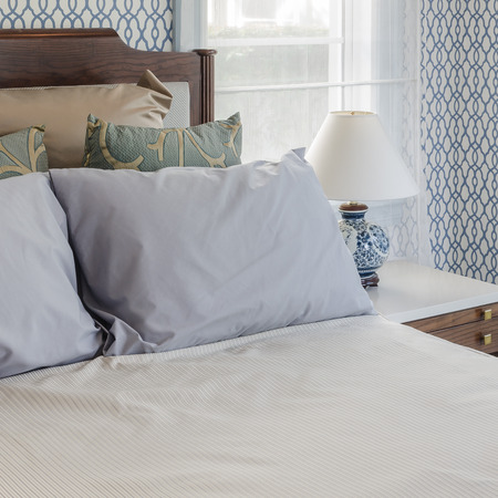 grey pillows on wooden bed in luxury bedroom