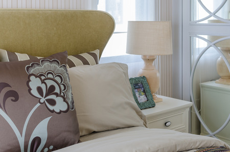 lamp and frame on table side in bedroomの写真素材